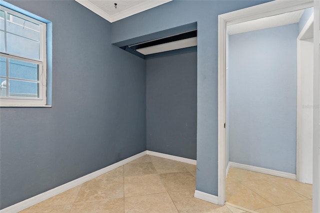 spare room featuring tile patterned floors and ornamental molding