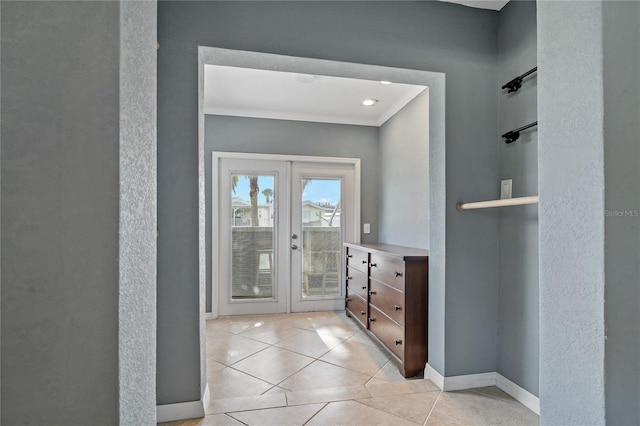 interior space with light tile patterned flooring, french doors, and crown molding