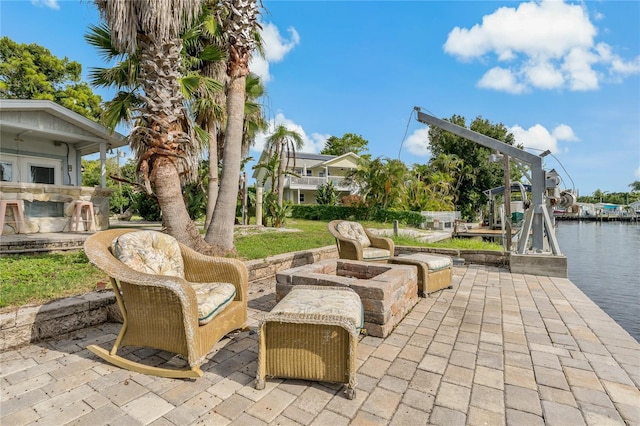 view of patio featuring a fire pit, a dock, and a water view