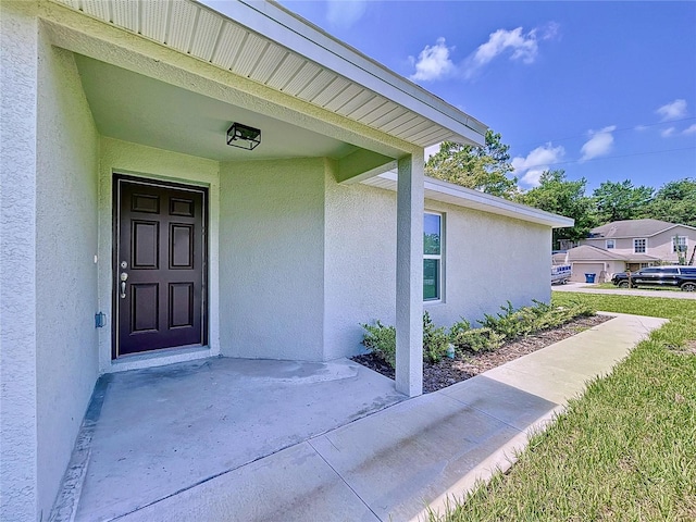 view of exterior entry with a lawn