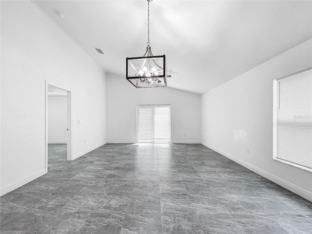 empty room with vaulted ceiling, an inviting chandelier, and dark tile patterned flooring