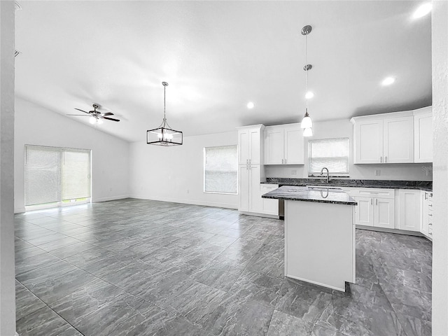 kitchen featuring decorative light fixtures, a healthy amount of sunlight, and dark tile patterned flooring