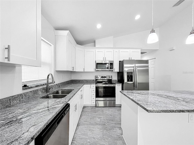 kitchen with decorative light fixtures, sink, appliances with stainless steel finishes, lofted ceiling, and light tile patterned floors