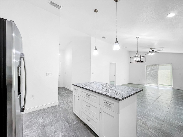 kitchen with tile patterned flooring, ceiling fan, white cabinets, and stainless steel fridge