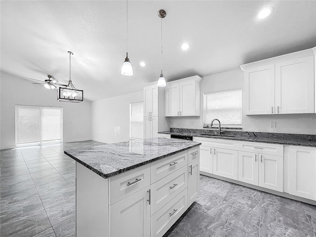 kitchen featuring pendant lighting, light tile patterned flooring, a center island, white cabinetry, and ceiling fan