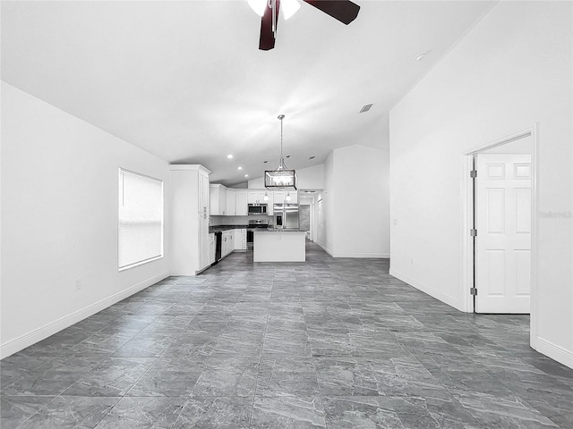 unfurnished living room with dark tile patterned floors, lofted ceiling, and ceiling fan