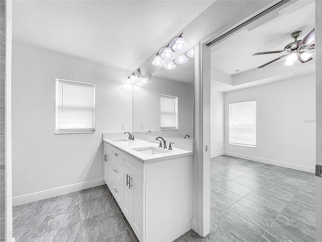 bathroom with ceiling fan, a textured ceiling, tile patterned floors, and dual bowl vanity