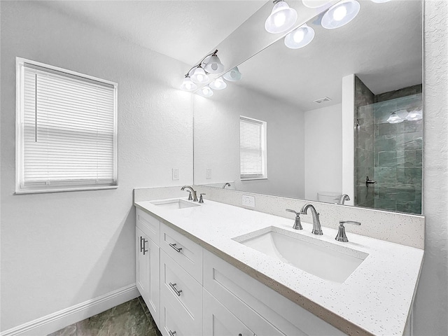 bathroom with tile patterned flooring, a shower with shower door, a wealth of natural light, and dual bowl vanity