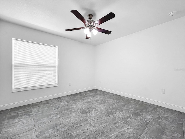 tiled spare room featuring ceiling fan