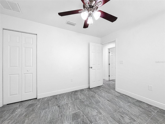 unfurnished bedroom with ceiling fan, tile patterned floors, and a closet