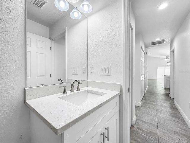 bathroom featuring tile patterned flooring, a textured ceiling, vanity, and ceiling fan