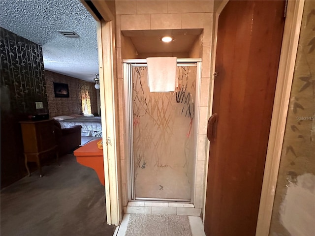 bathroom with a shower with shower door and a textured ceiling