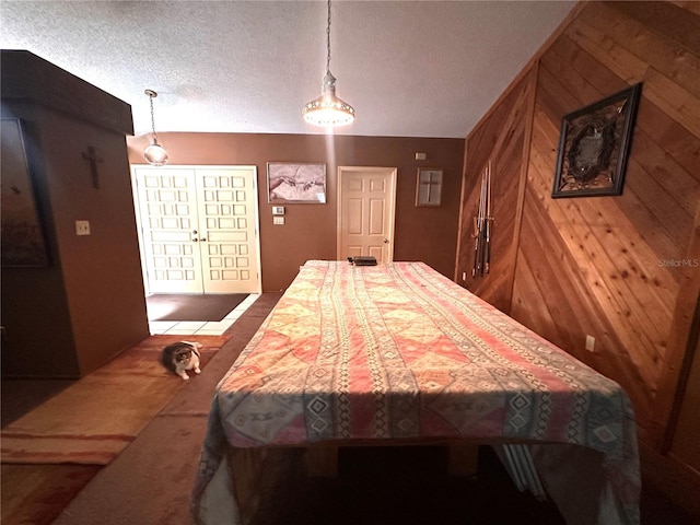 bedroom with a textured ceiling and wood walls