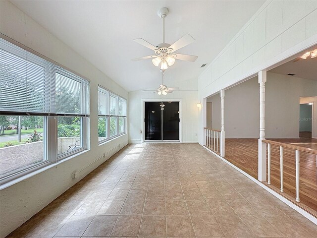 unfurnished sunroom with ceiling fan, lofted ceiling, and ornate columns