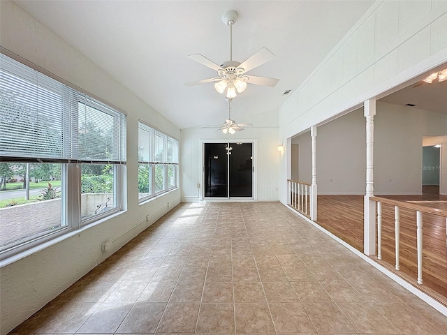 unfurnished sunroom with ornate columns, ceiling fan, and vaulted ceiling