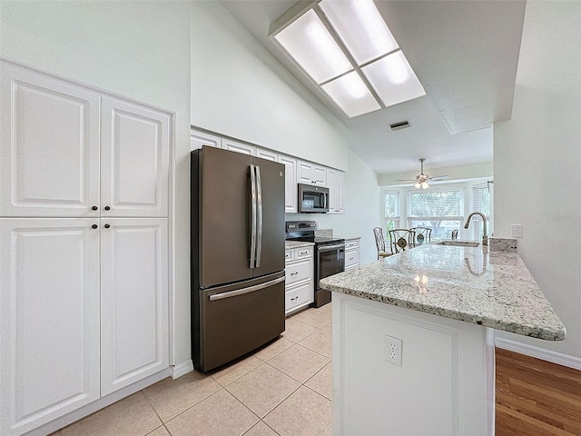 kitchen with kitchen peninsula, stainless steel appliances, ceiling fan, white cabinetry, and lofted ceiling