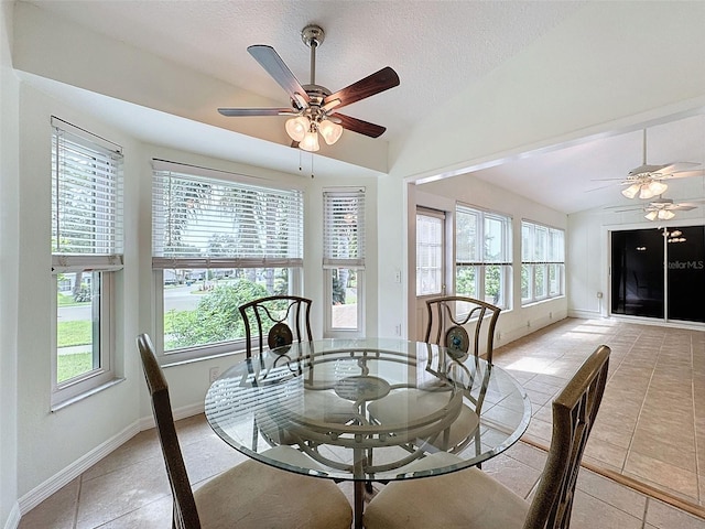 tiled dining room featuring ceiling fan, lofted ceiling, and a textured ceiling