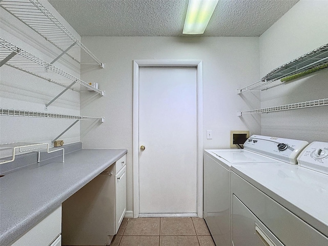 washroom featuring independent washer and dryer, light tile patterned floors, and a textured ceiling