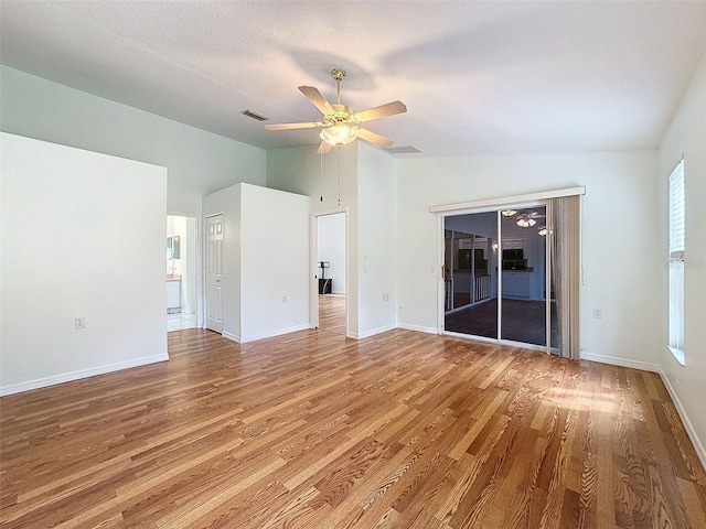 unfurnished living room featuring ceiling fan, light hardwood / wood-style floors, a healthy amount of sunlight, and vaulted ceiling