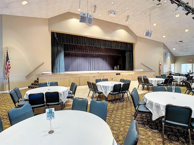 dining area featuring carpet flooring and high vaulted ceiling