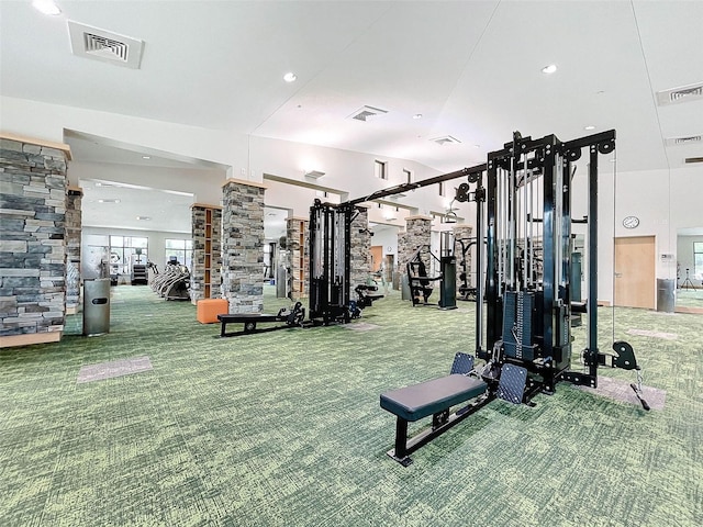 gym featuring decorative columns and carpet