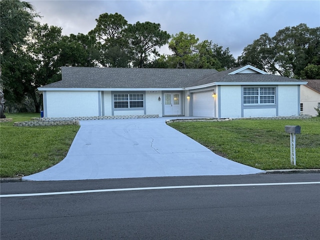 single story home featuring a front yard and a garage