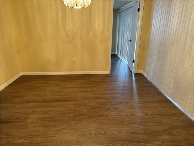 empty room featuring dark hardwood / wood-style floors and a chandelier