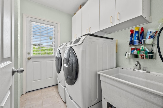 laundry area featuring cabinets, sink, washing machine and dryer, and light tile patterned floors