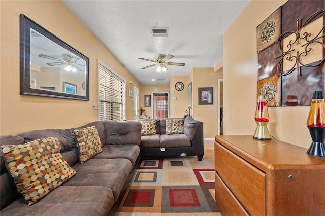 living room featuring a textured ceiling and ceiling fan