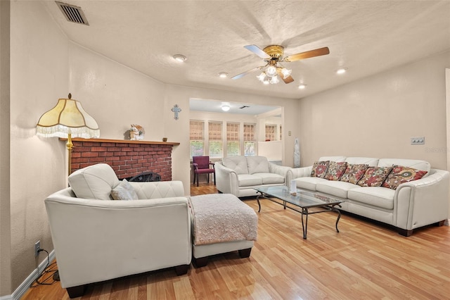 1501 28th Ave N, Saint Petersburg, FL 33704 - living area featuring a fireplace, light wood-type flooring, visible vents, baseboards, and ceiling fan