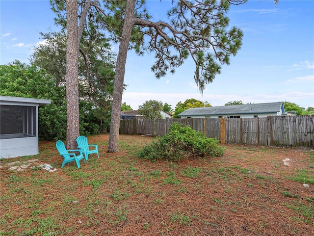 view of yard with fence and a sunroom