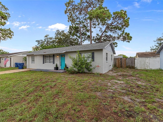 view of front of home with a front lawn and a storage shed