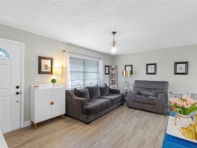 living room with a textured ceiling and light hardwood / wood-style floors