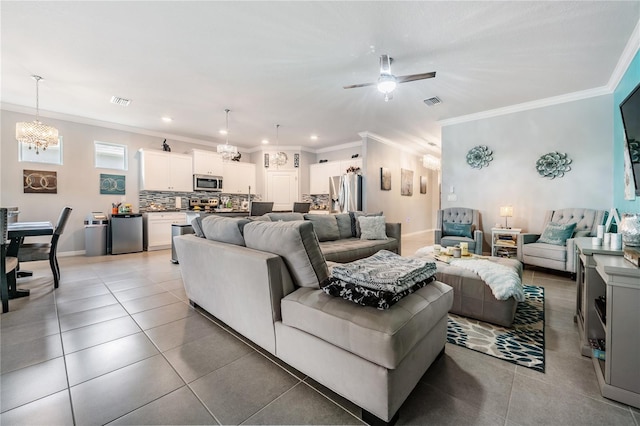 living room featuring ceiling fan with notable chandelier, crown molding, and light tile patterned floors