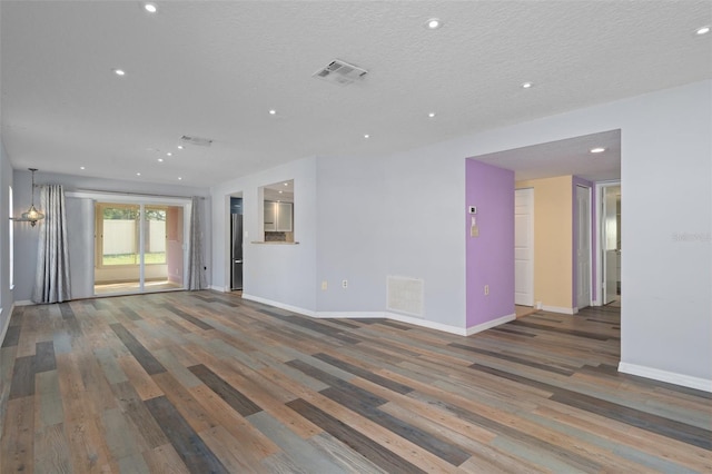 unfurnished living room featuring a textured ceiling and wood-type flooring