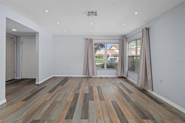 spare room featuring hardwood / wood-style flooring and a textured ceiling