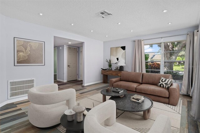 living room featuring a textured ceiling and hardwood / wood-style floors