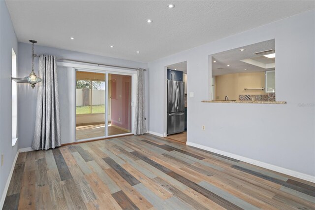 empty room featuring a textured ceiling and hardwood / wood-style floors