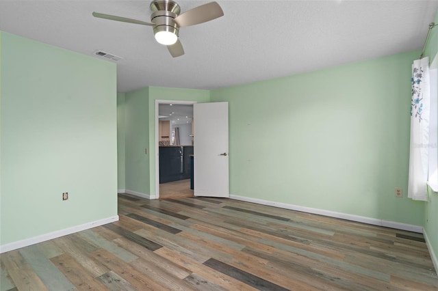 empty room featuring ceiling fan and hardwood / wood-style floors