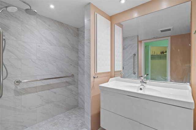 bathroom with vanity and a tile shower