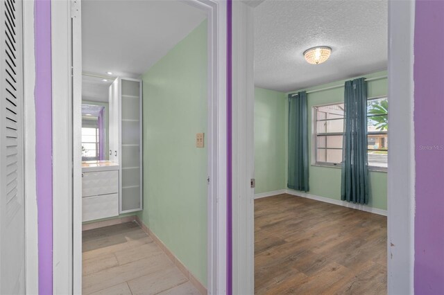 hallway with wood-type flooring and a textured ceiling