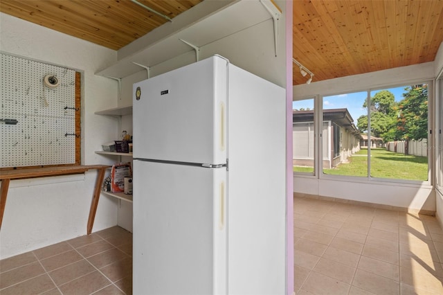 kitchen with white fridge, light tile patterned floors, and wooden ceiling