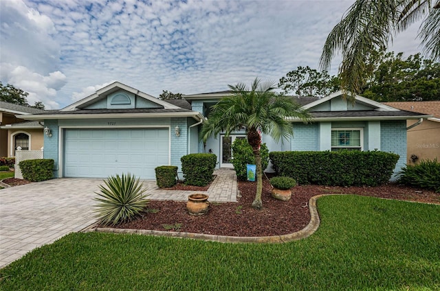 ranch-style home with a garage and a front lawn