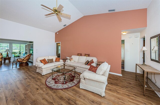 living room with wood-type flooring, ceiling fan, and high vaulted ceiling