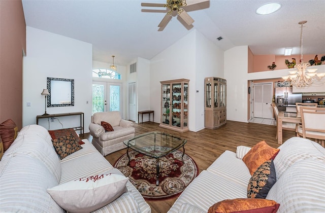 living room featuring french doors, hardwood / wood-style flooring, high vaulted ceiling, and ceiling fan with notable chandelier