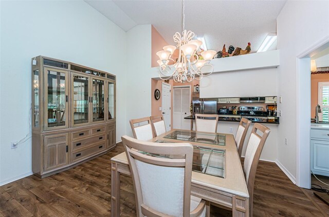 dining room with dark hardwood / wood-style floors, a notable chandelier, and high vaulted ceiling