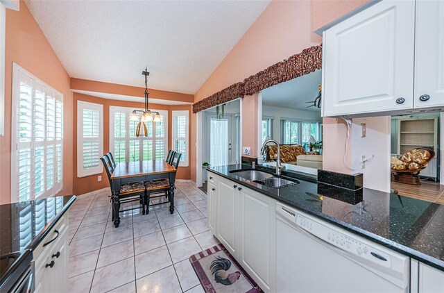 kitchen with dark stone countertops, sink, pendant lighting, white dishwasher, and white cabinets