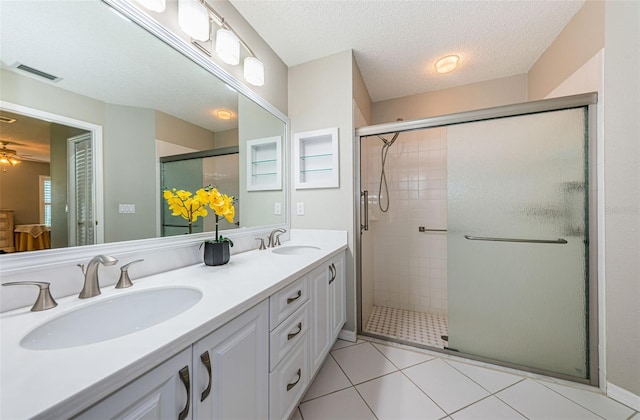 bathroom with ceiling fan, an enclosed shower, vanity, and a textured ceiling