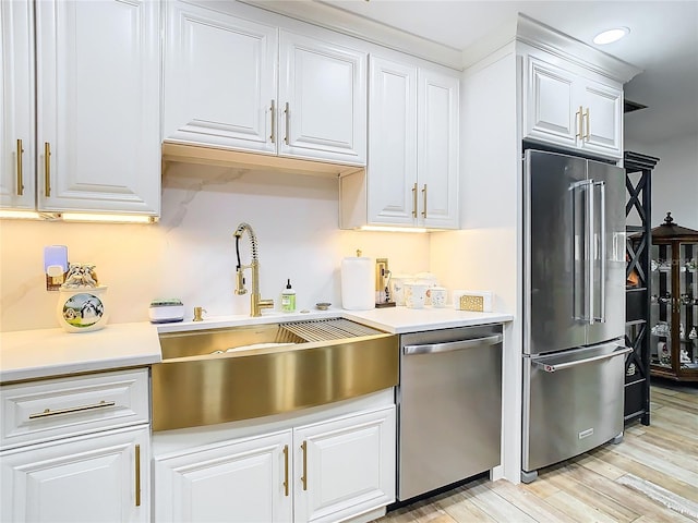 kitchen featuring light hardwood / wood-style floors, sink, stainless steel appliances, and white cabinets