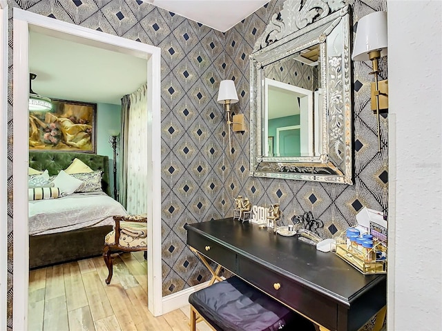 bedroom with hardwood / wood-style flooring, wallpapered walls, and baseboards